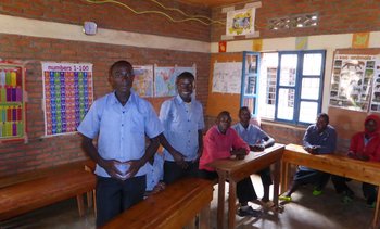 Sechs junge afrikanische Männer stehen oder sitzen in einem Klassenraum einer Schule des Centre Urugwiro in Ruanda.
